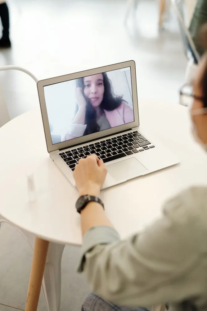 A therapist using a laptop at their practice desk